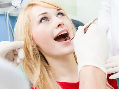 Female patient in dentist office getting oral exam procedure do